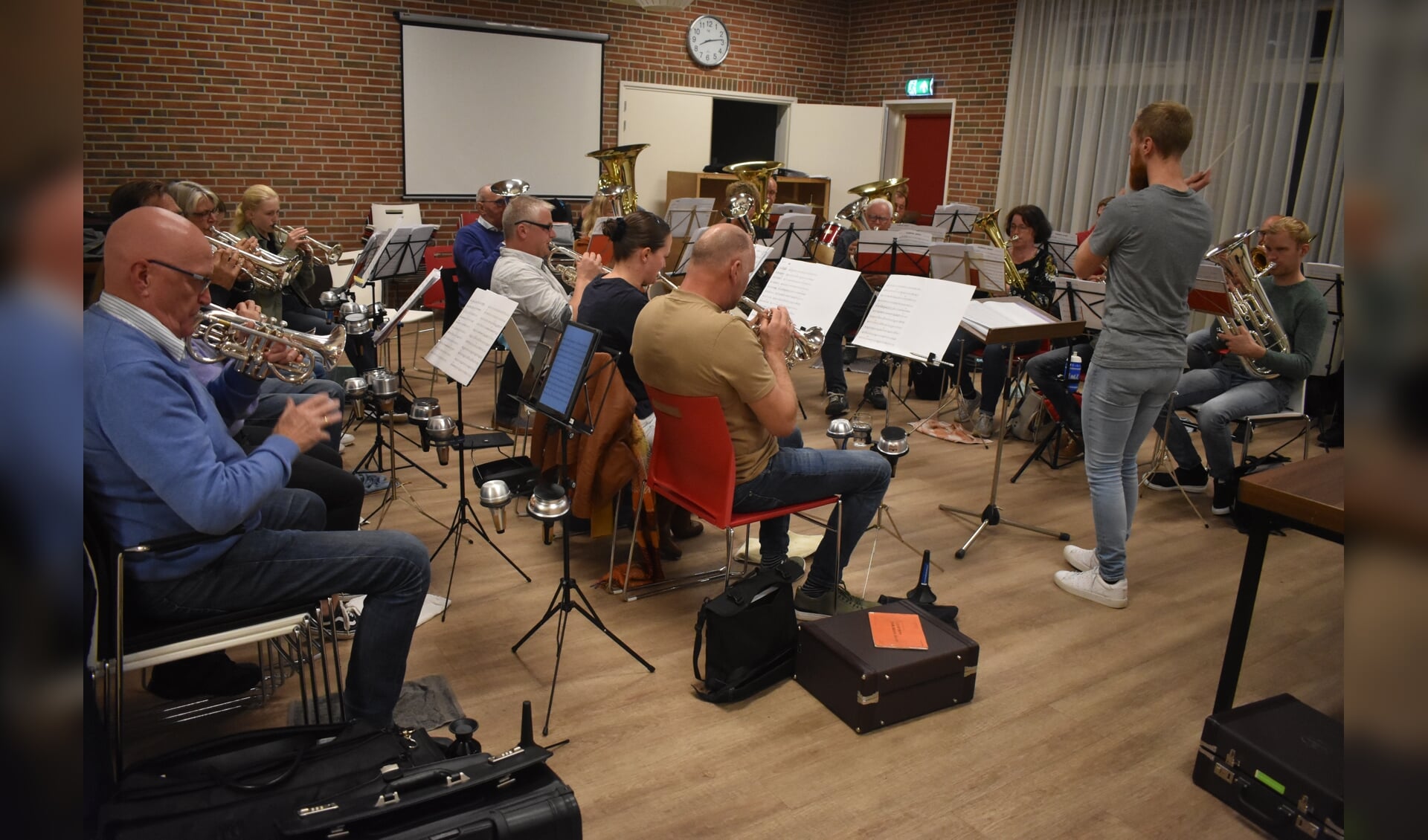 Brassband Halleluja repeteert in De Nije Kompe en viert daar donderdag 21 oktober het 100-jarig bestaan. Staand dirigent Chris van der Veen uit Ternaard.