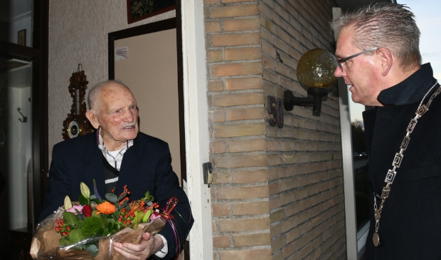 <p>De heer Sijbe Bijlsma krijgt bloemen van burgemeester Jeroen Gebben.</p> 