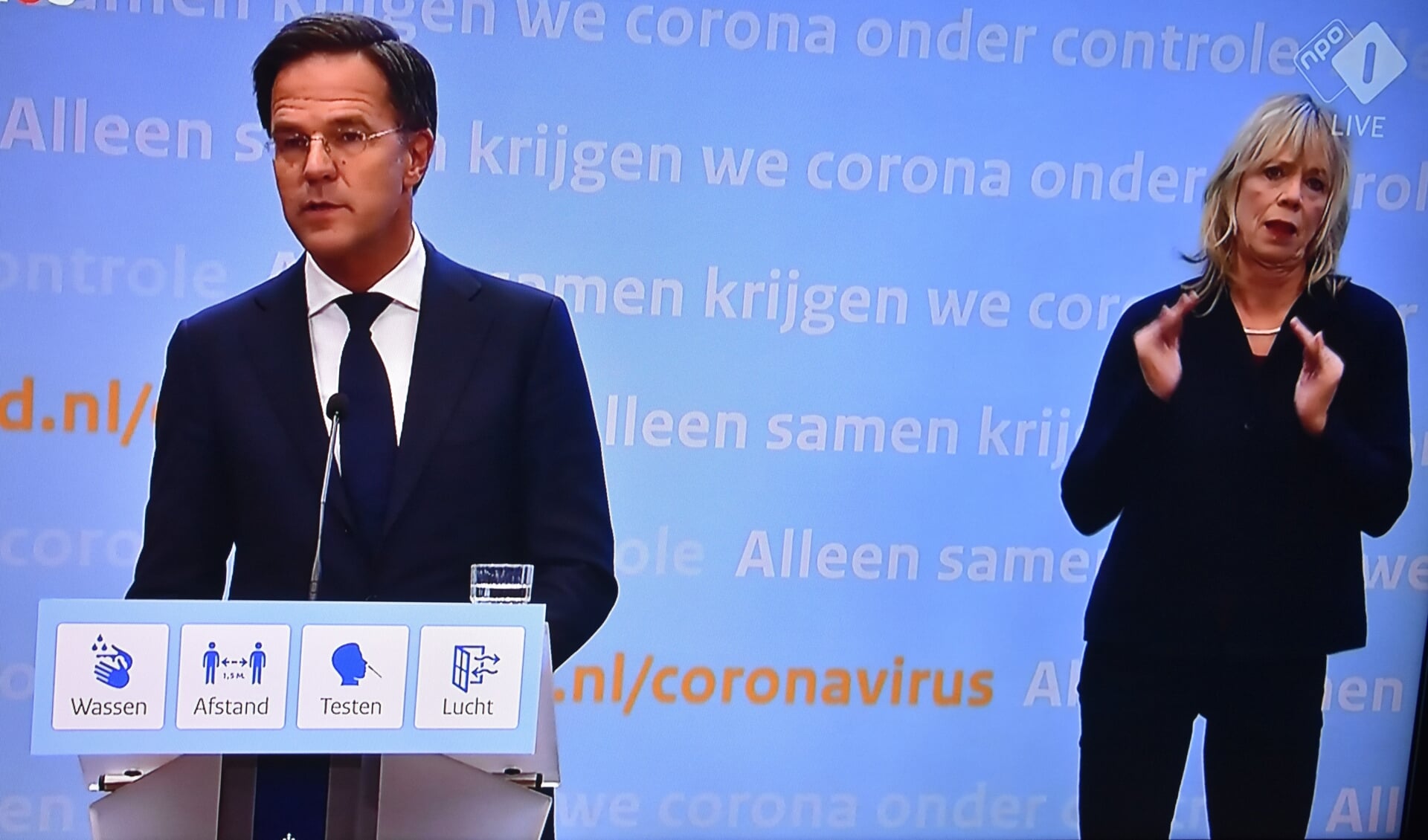 Premier Rutte en een gebarentolk tijdens de persconferentie van 12 november 2021.