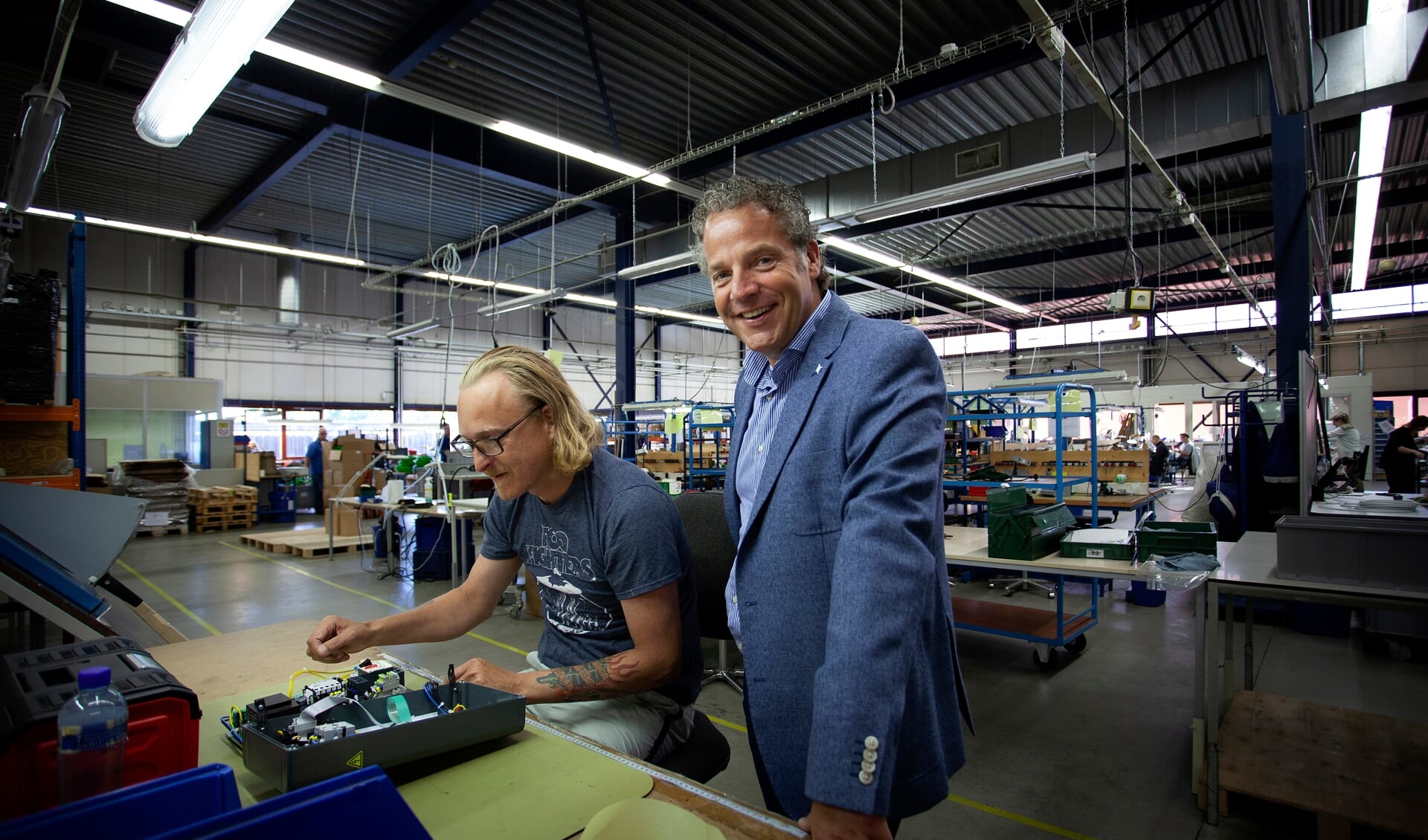 Directeur Alex Bonnema (rechts) op bezoek in de elektro-afdeling van Caparis in Drachten.