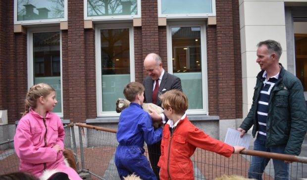 <p>Commissaris van de Koning Arno Brok geeft een lam terug aan Thomas Bouma. Z'n zus Siegrid (links) en broer Lars en vader Jehan Bouma kijken toe.</p>