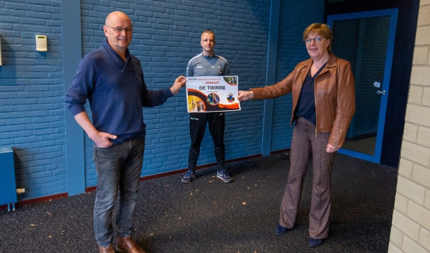 Wethouder Gelbrig Hoekstra reikt de prijs uit aan Gosse Bies, directeur basisschool De Twirre. Op de achtergrond Liekele Paulusma, buurtsportcoach en bedenker van de beweegchallenge.