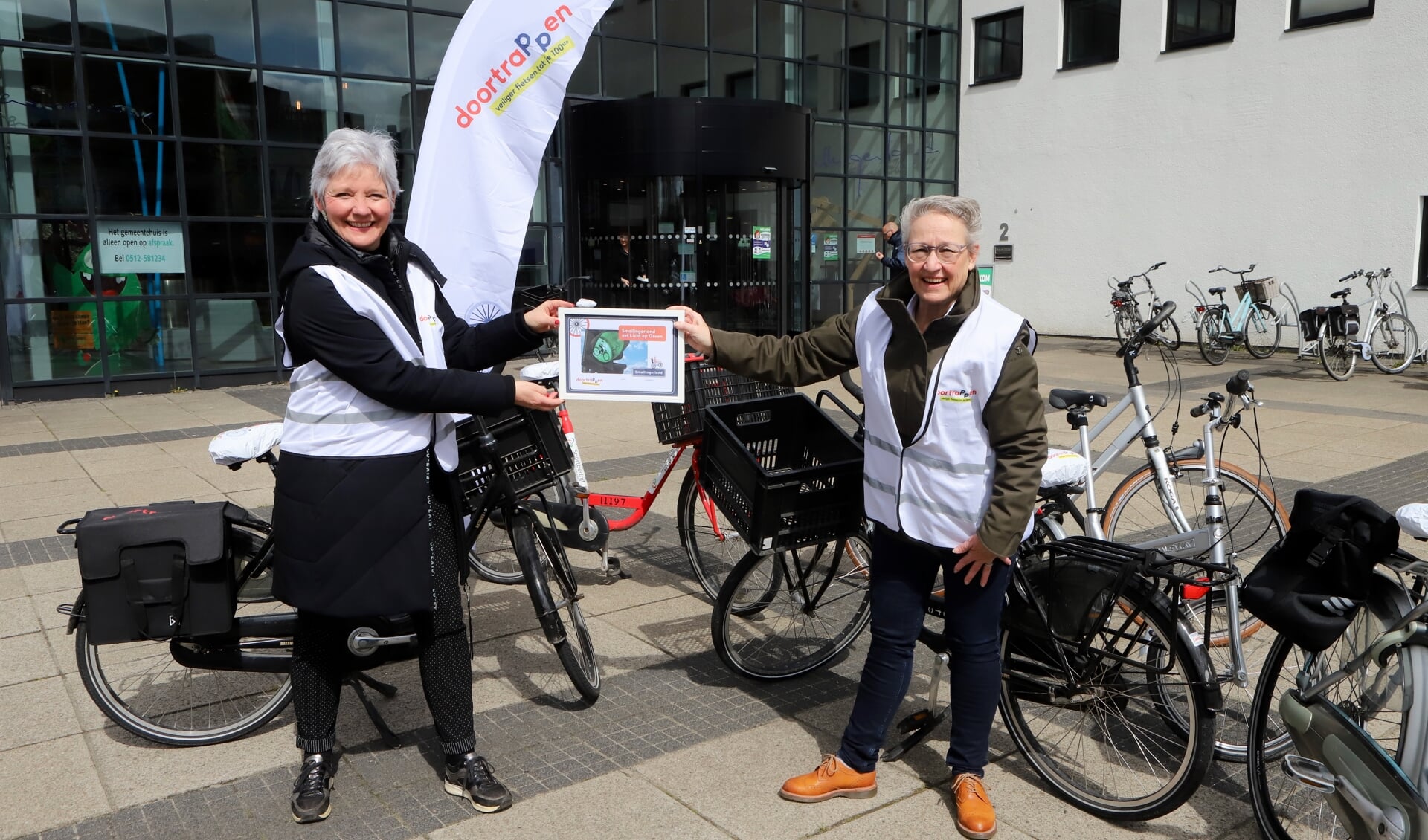 Wethouder Maria le Roy nam de oorkonde én een fietstas in ontvangst van Evelien Karrenbelt van het Regionaal Orgaan Verkeersveiligheid van de Provincie Fryslân.