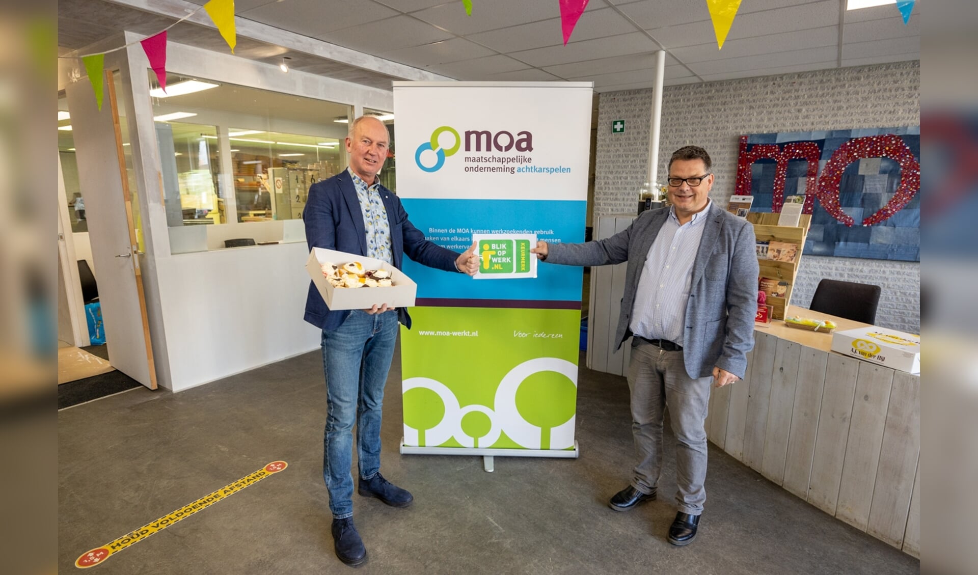 Wethouder Harjan Bruining (links) bezorgt MOA-directeur Sipko Postma een taart.