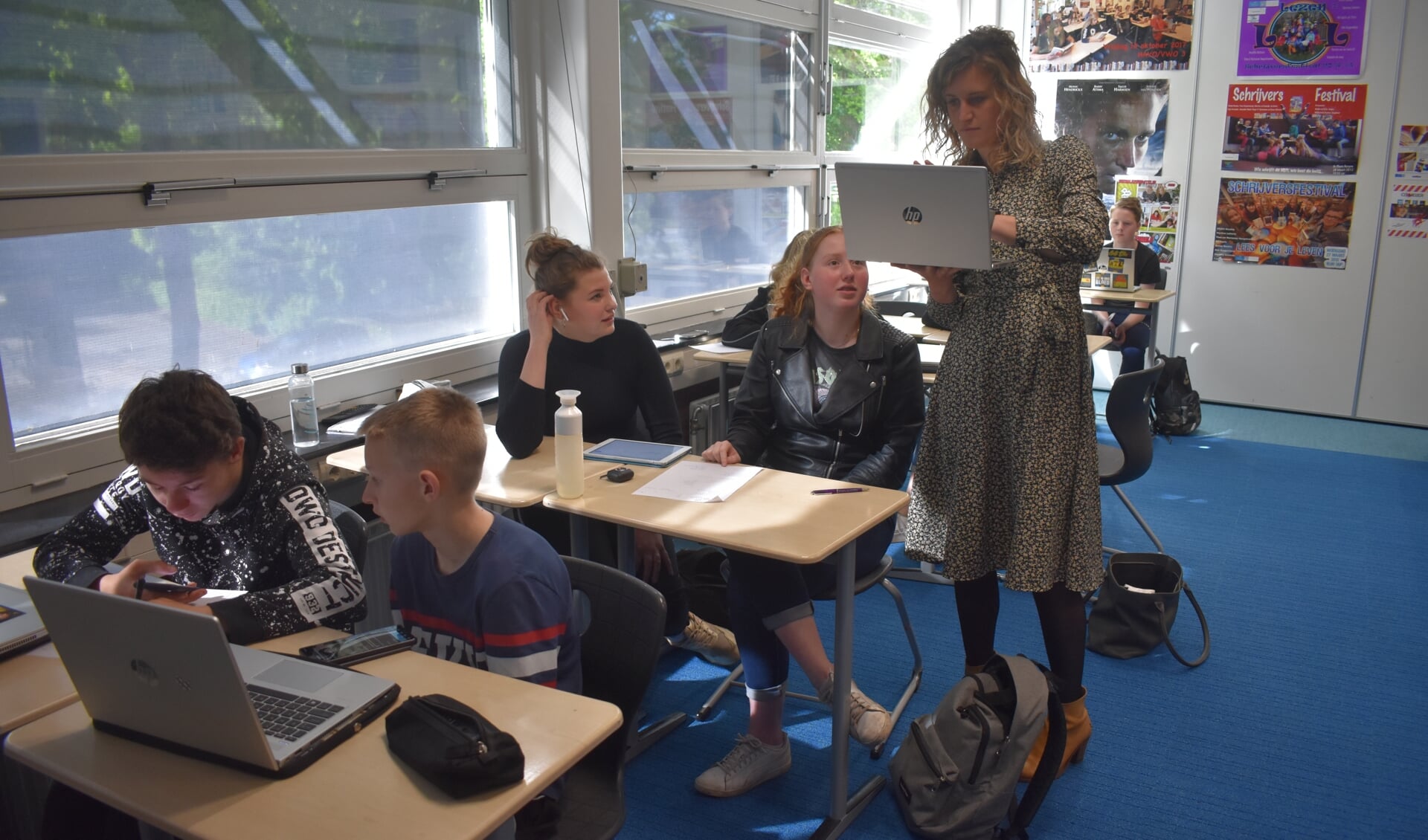 Docente Monique de Graaf helpt enkele leerlingen met de 'digitale escaperoom'.