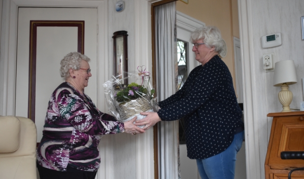 Jannie Smith (links) kreeg vrijdag al vast een plant uit handen van Alie Hofstra-Veenstra. Het officiële afscheidsfeestje moet wachten vanwege het coronavirus.