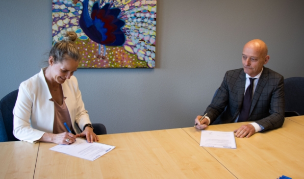 <p>Directeur Publieke Gezondheid, Margreet de Graaf van GGD Fryslân en Vincent Maas, voorzitter van de Raad van Bestuur van Zorggroep Alliade, ondertekenen het convenant.</p>