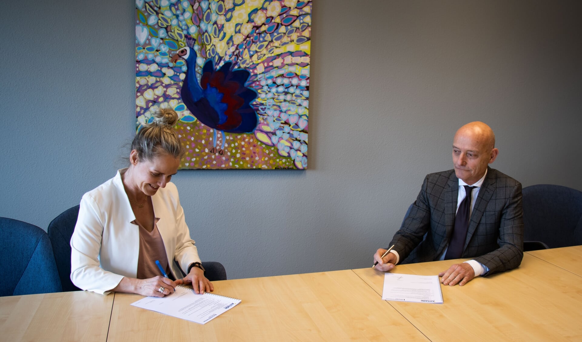 Directeur Publieke Gezondheid, Margreet de Graaf van GGD Fryslân en Vincent Maas, voorzitter van de Raad van Bestuur van Zorggroep Alliade, ondertekenen het convenant.
