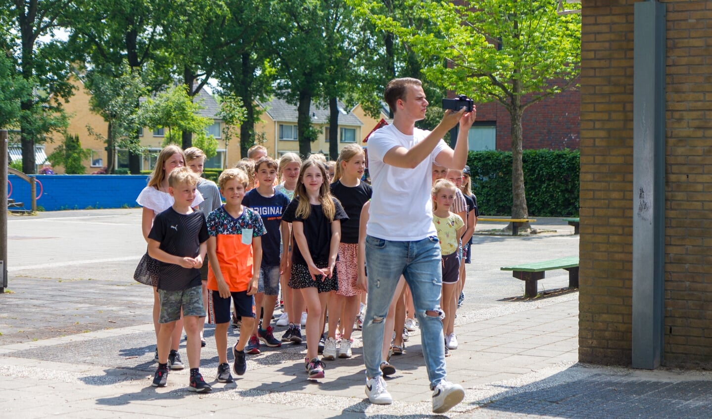 Groep 6 loopt samen met YouTuber Jordy Storm het plein op. 