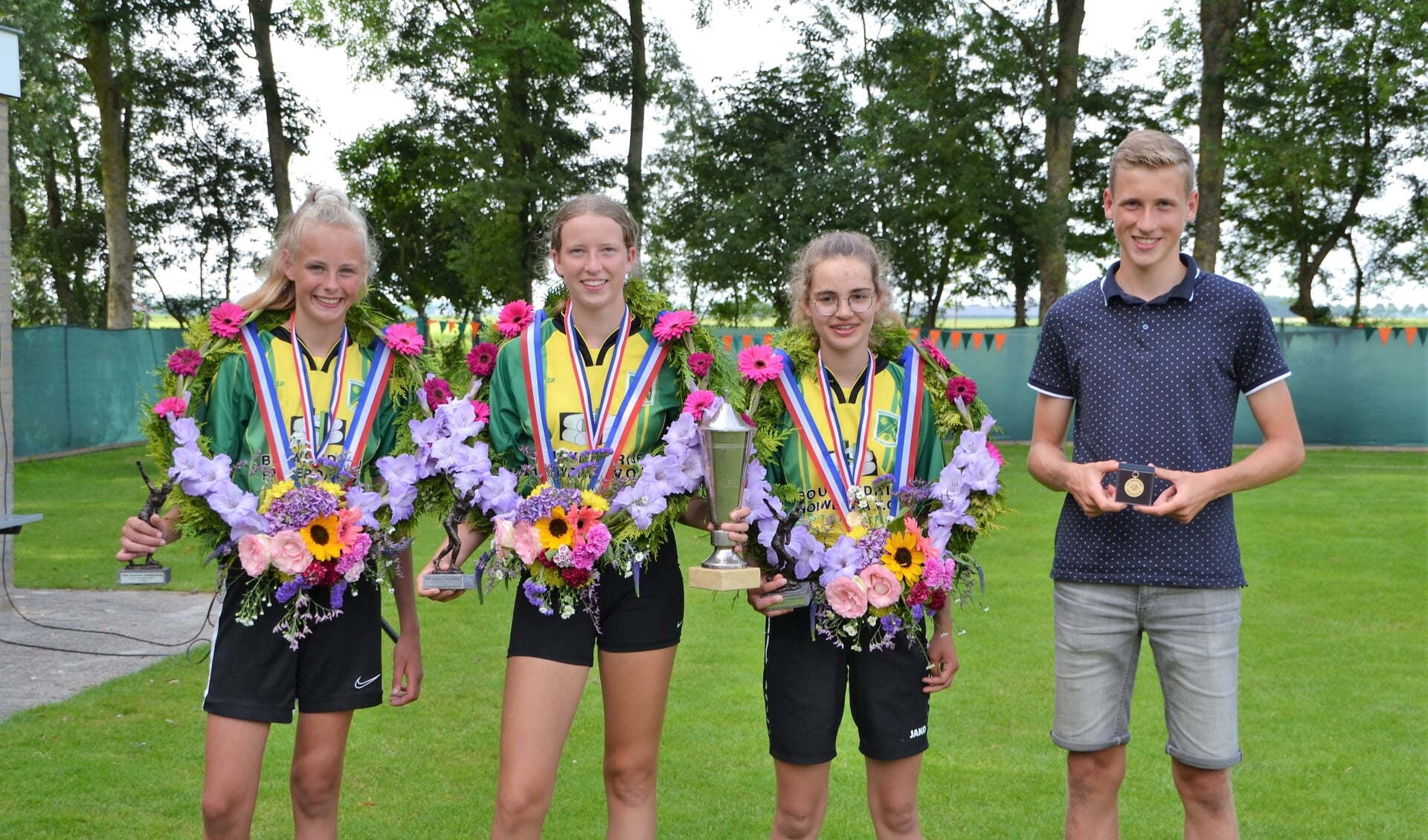 De drie meisjes van Kf De Trije Doarpen met hun prijzen, en coach Jemer Torensma.