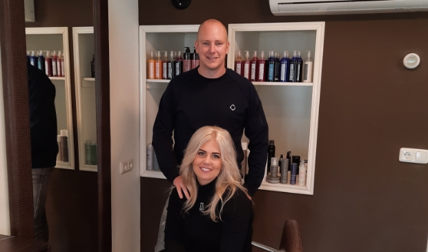 <p>Kapster Michelle Kooistra en haar man Marcel in hun haarboetiek.</p>