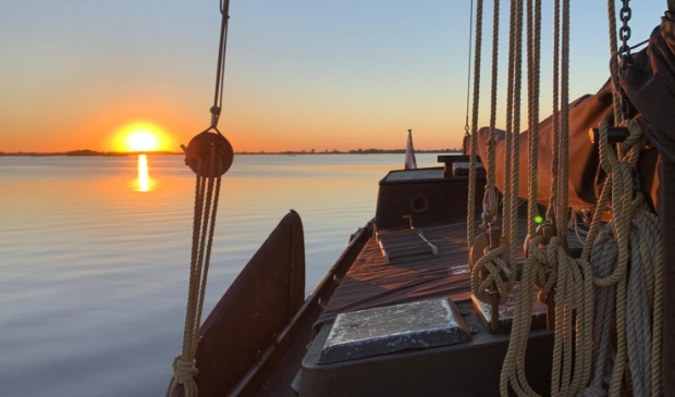 Varen bij zonsondergang met skûtsje De Rot.