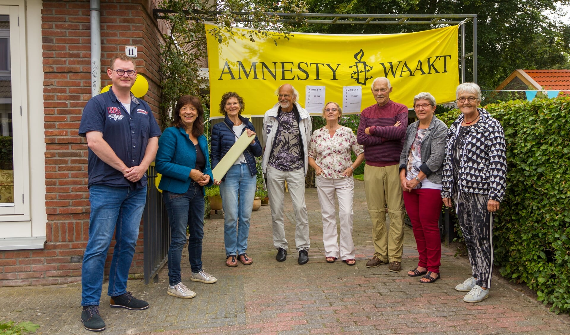 Het bestuur van Amnesty Burgum zet Agaath van Dalfsen in het zonnetje. Van links naar rechts: Bas van der Zeep, Hetty Thomson, Agaath en Ben van Dalfsen, Jellie en Iko Zijlstra, Boukje Hietkamp en Sytske Wolters. 