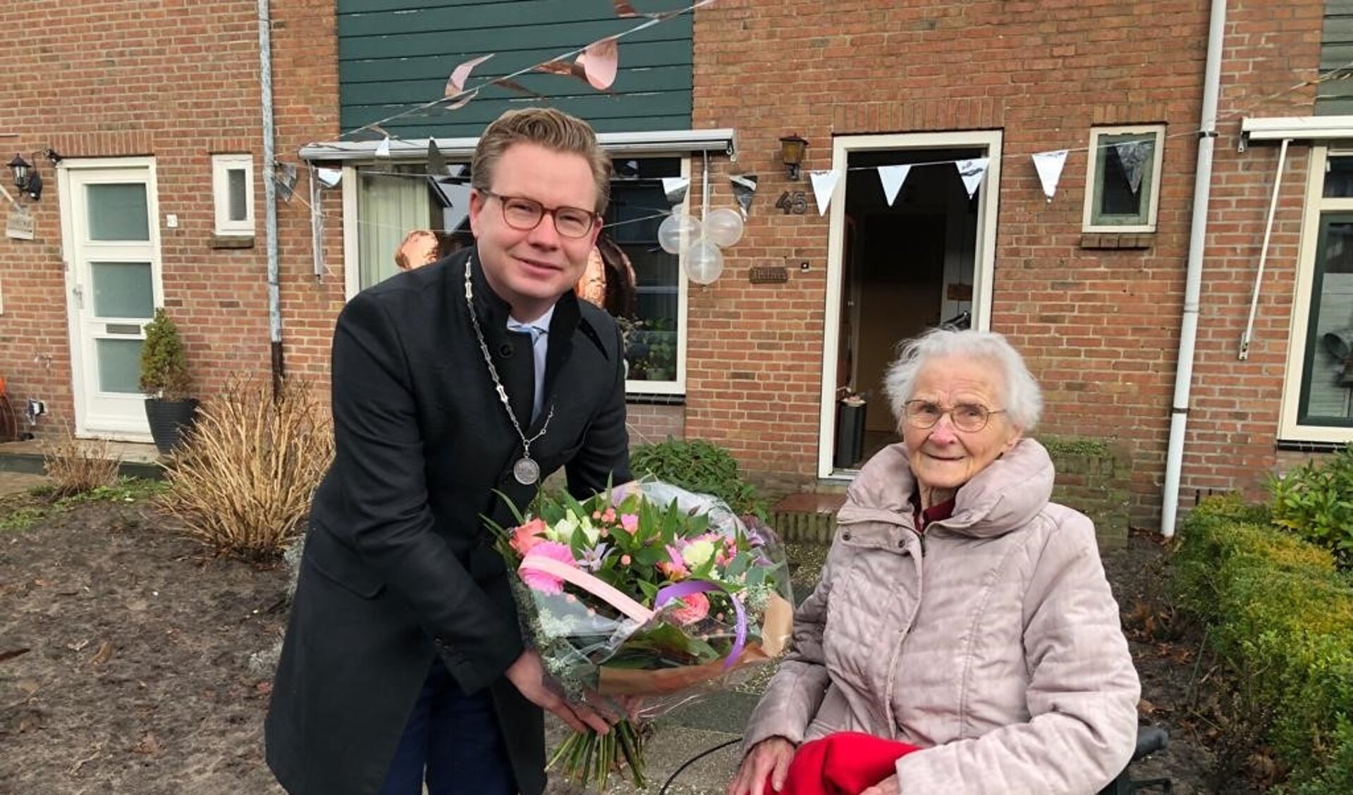 Locoburgemeester en wethouder Andries Bouwman feliciteert Rinske Hofstra met haar honderdste verjaardag.