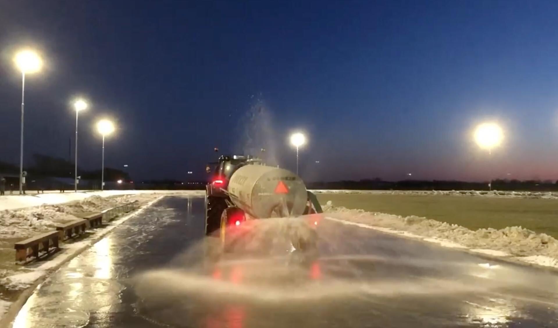 De ijsbaan in Burgum (in 2021) met trekker en giertank onder water gezet. 