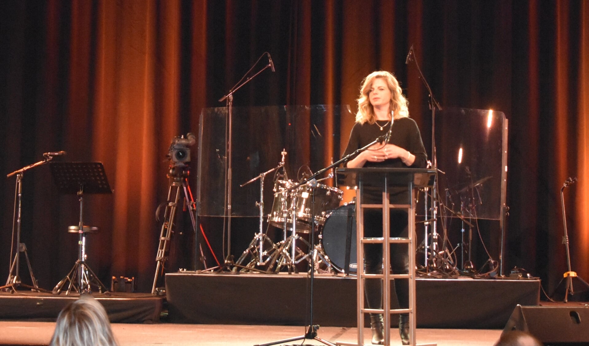 Amanda v.d. Veen namens M.O.S. op het grote podium in de grote zaal van de Bethelkerk in Drachten.
