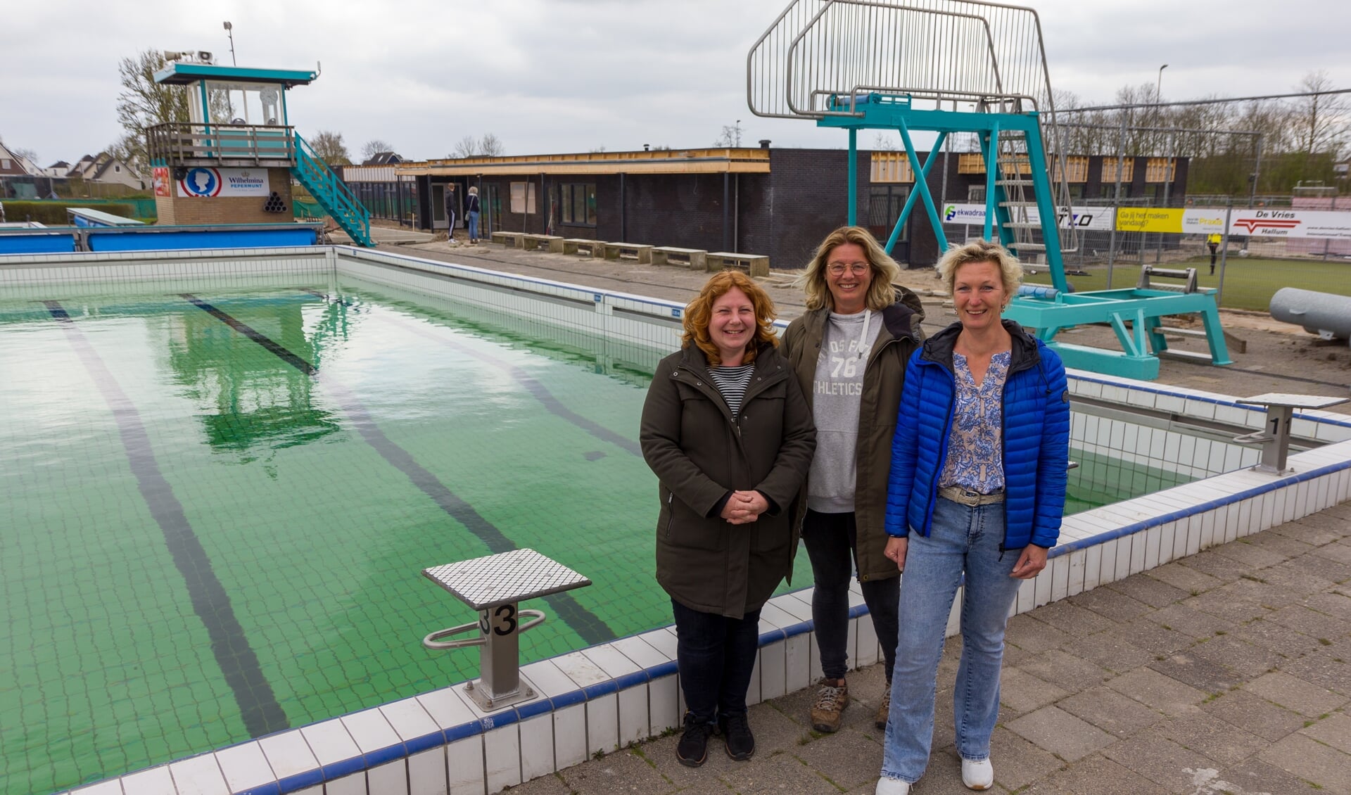 Van links naar rechts: Fetsje Kramer, Jacoba Wijbenga en Jantine Kuiken bij het zwembad, met op de achtergrond de nieuwe accommodatie ‘Bruisend Hart’. 