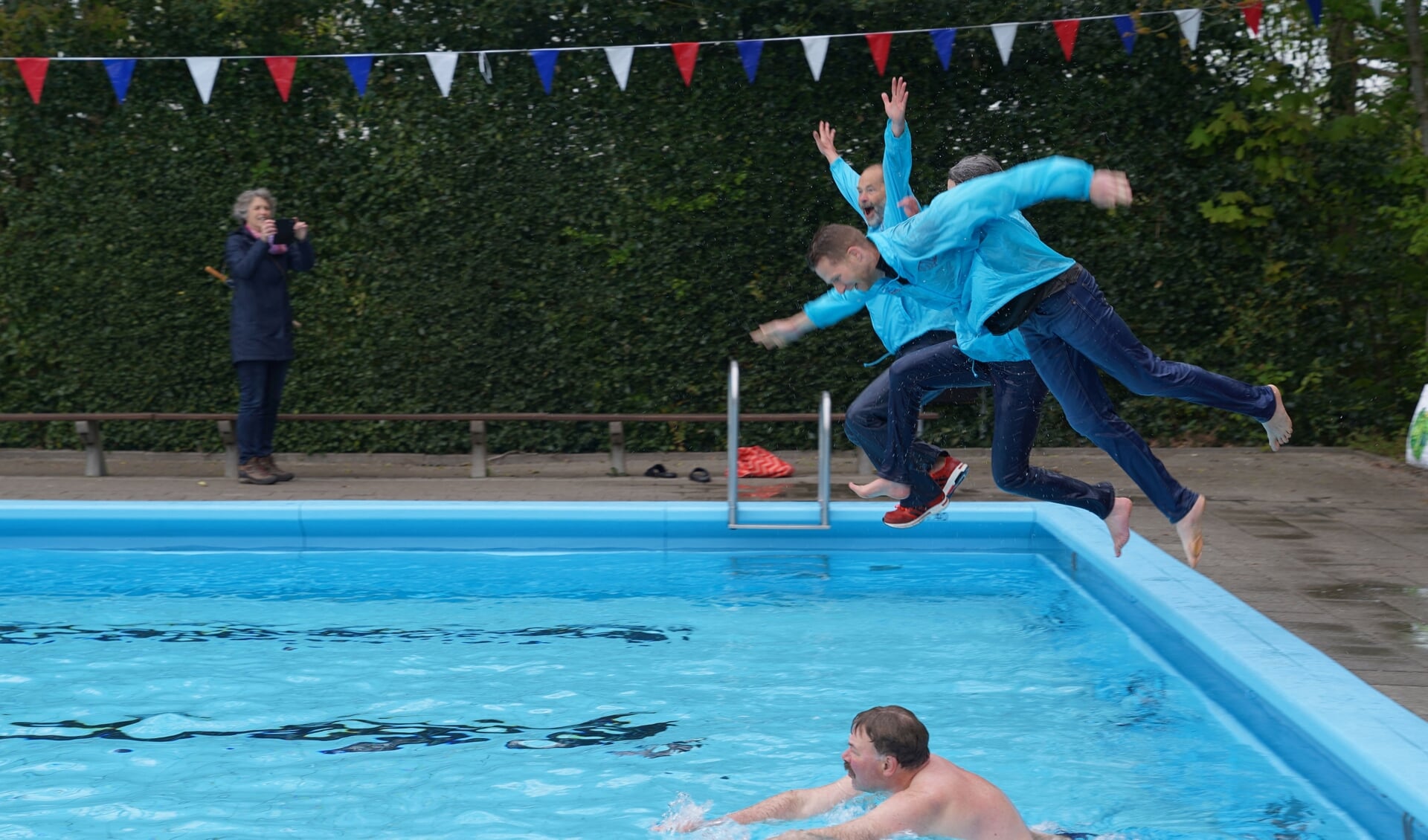 De bestuursleden van Stichting Swim! heropenden het zwembad in Gytsjerk met een vrolijke duik in het water.