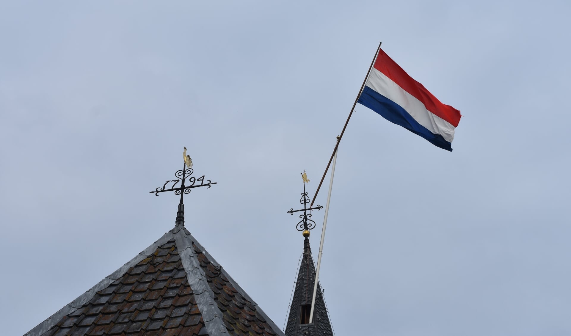 De Nederlandse vlag in top van de toren van de Agneskerk in Earnewâld, donderdag 5 mei 2022.
