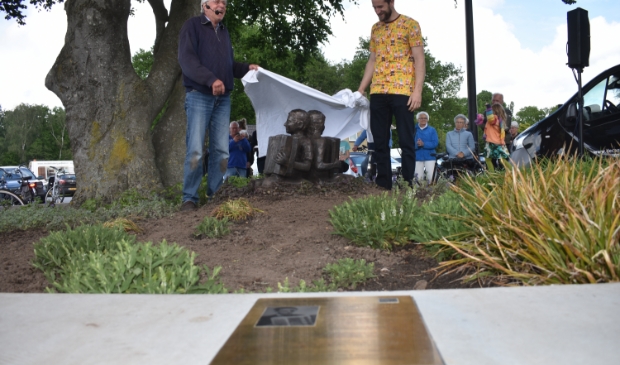 <p>Beeldend kunstenaar Oene van der Veen (links) en bronsgieter Van der Kleij onthullen het nieuwe beeld in Gytsjerk. Een plaquette (voorgrond) geeft uitleg.</p> 
