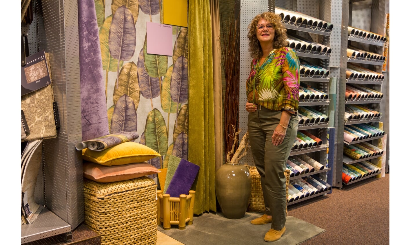 Marjon de Vries bij een sfeervol ingericht hoekje in de winkel met de nieuwste trendkleuren.
