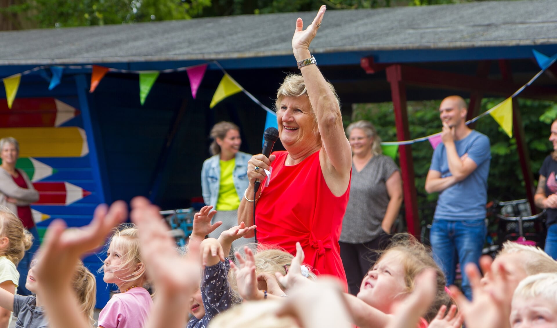 Directeur Tineke Vogels zwaait samen met de kinderen naar de drone. 