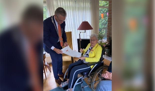 <p>Burgemeester Jeroen Gebben reikt de koninklijke onderscheiding uit aan mevrouw Hitje Dankert-Hoekstra.</p> 