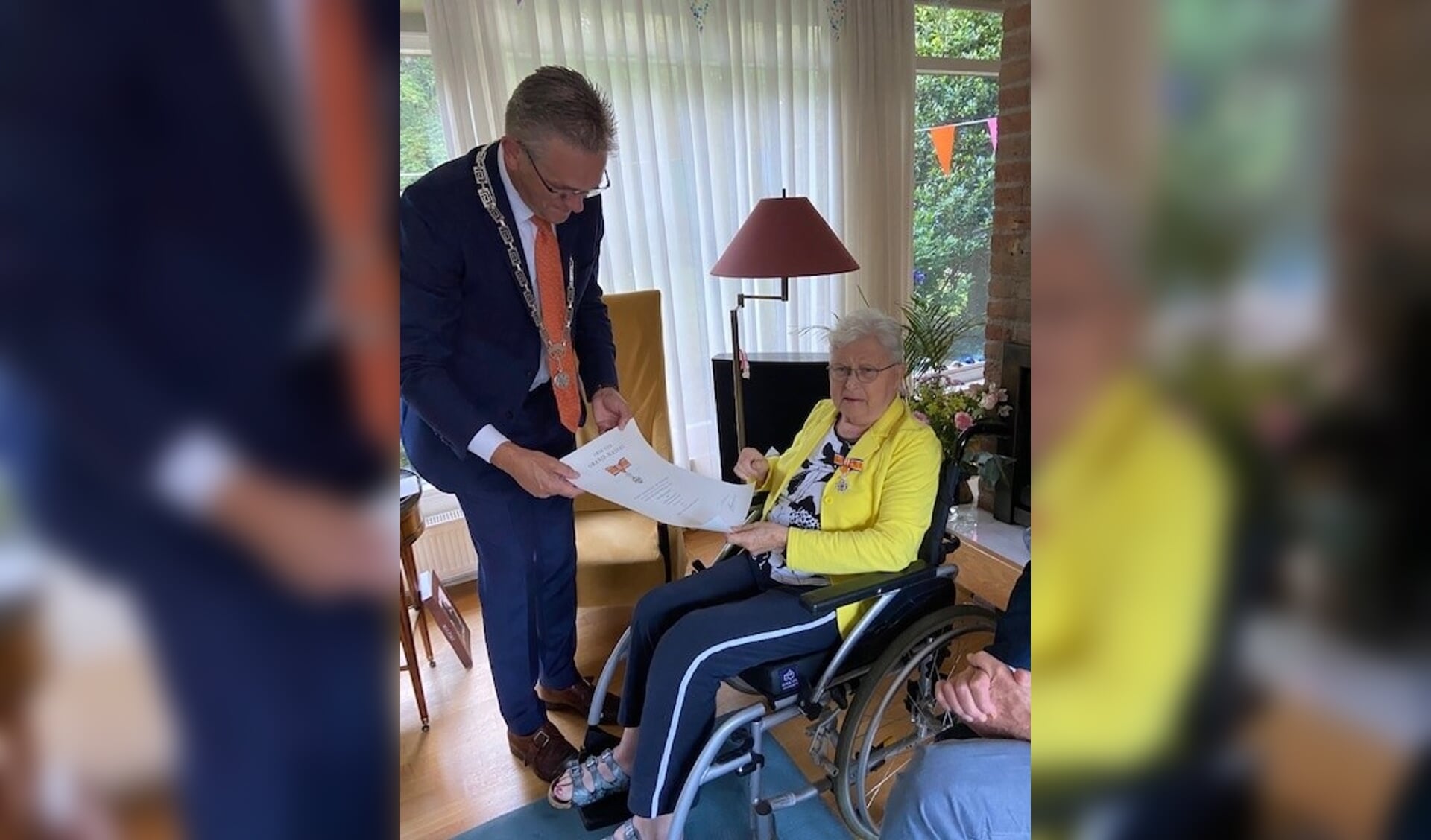 Burgemeester Jeroen Gebben reikt de koninklijke onderscheiding uit aan mevrouw Hitje Dankert-Hoekstra.
