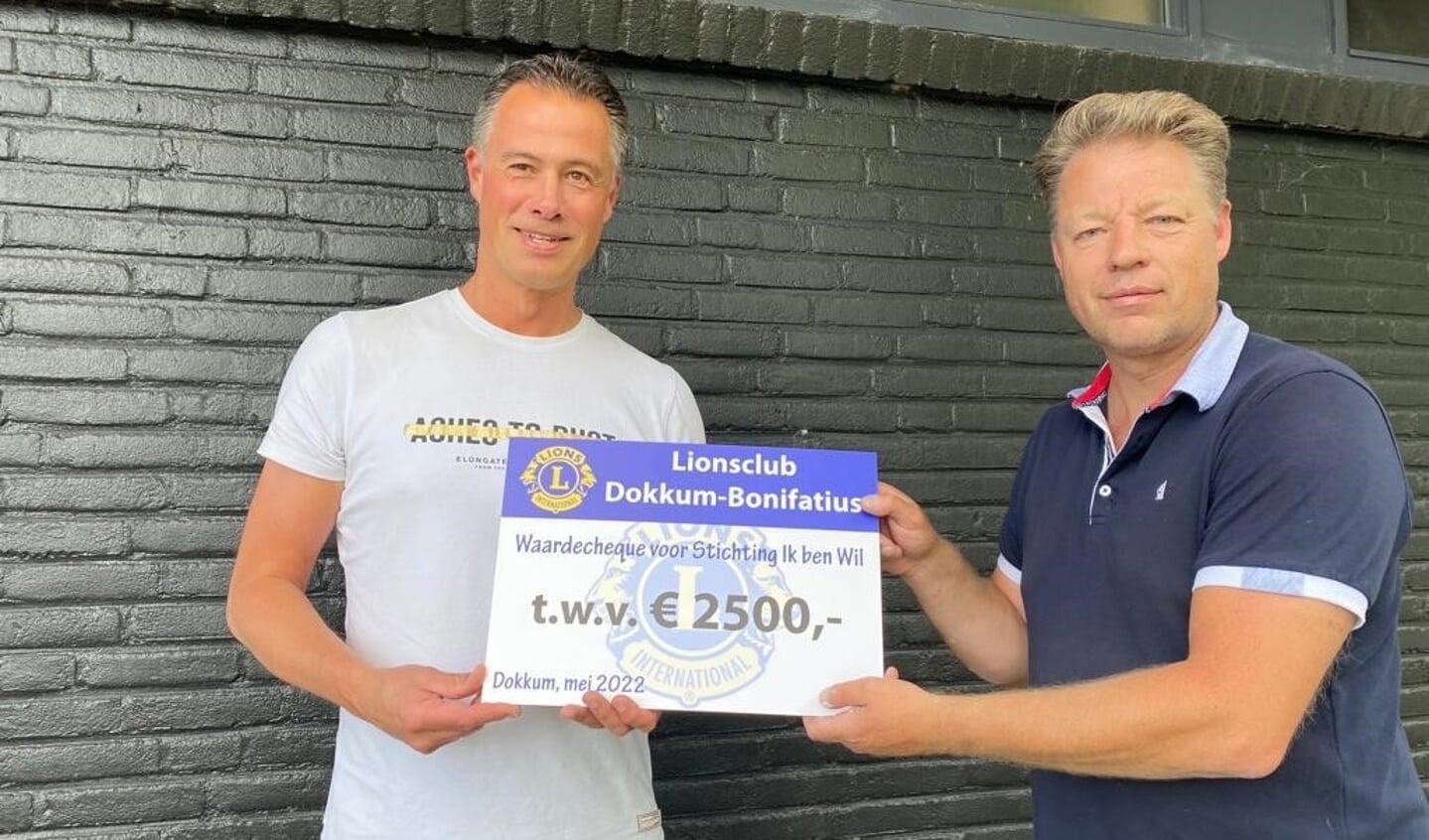 Edwin de Vries (rechts) van Lionsclub Dokkum-Bonifatius reikt de cheque uit aan Dennis Mellink van de stichting Ik Ben Wil.
