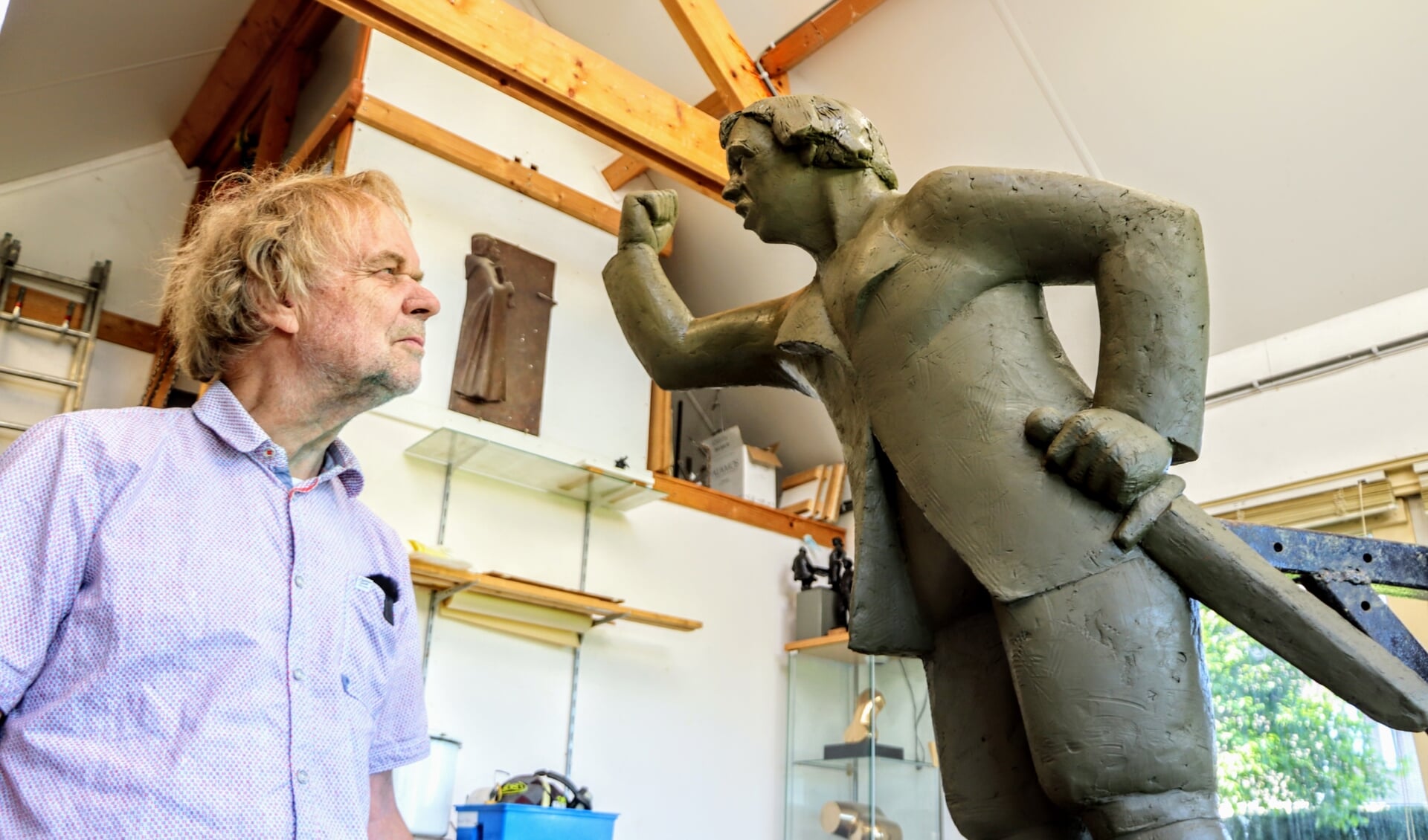 Kunstenaar Gosse Dam uit Kollum in zijn atelier tegenover een kwade Jan Binnes.