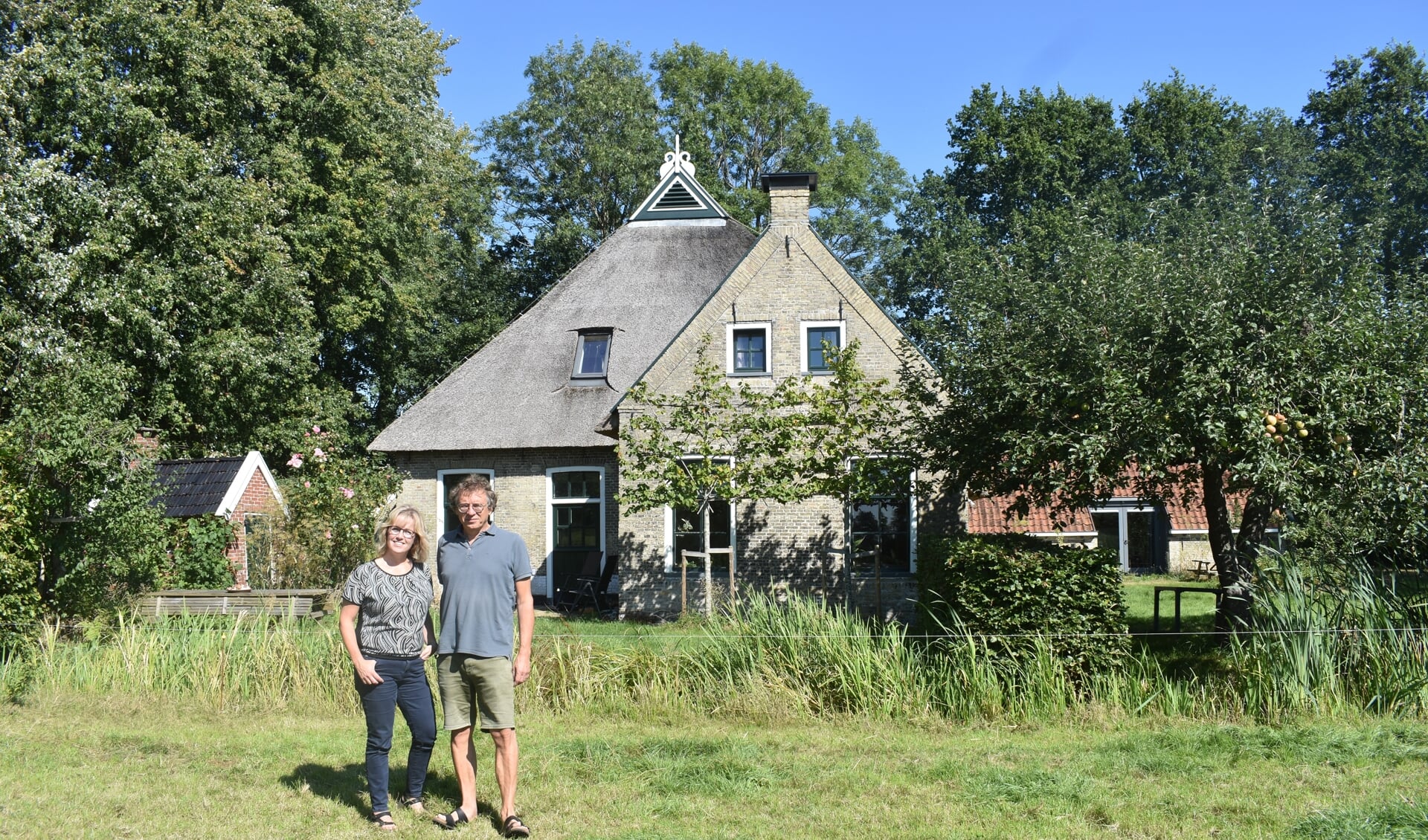 Wendy Battist en Mindert de Vries voor hun woonboerderij, stookhok (links) en het 'lytshûs' (rechts) bij Oudega.
