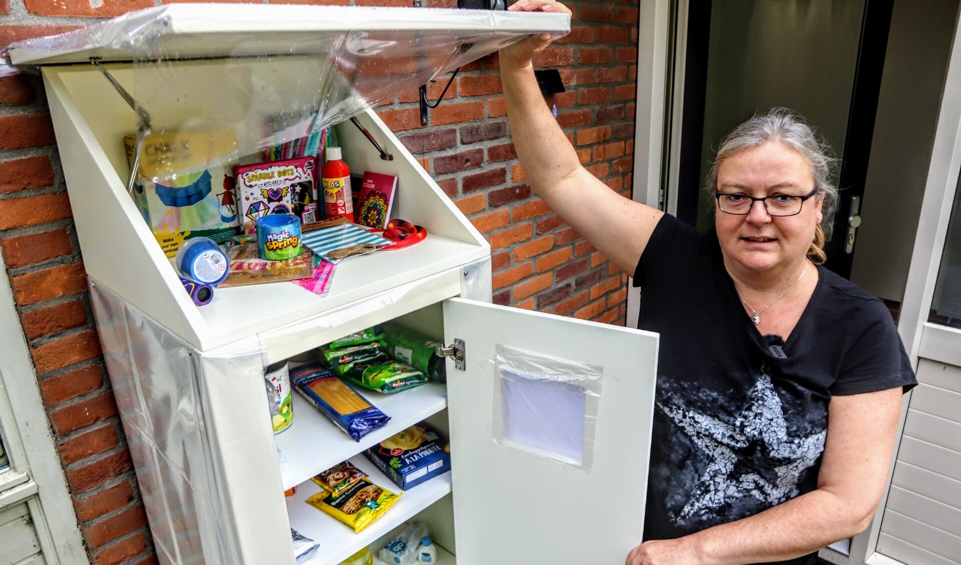 Mattie Dijkstra uit Drachten bij haar goed gevulde weggeefkast aan de Flevo 22.