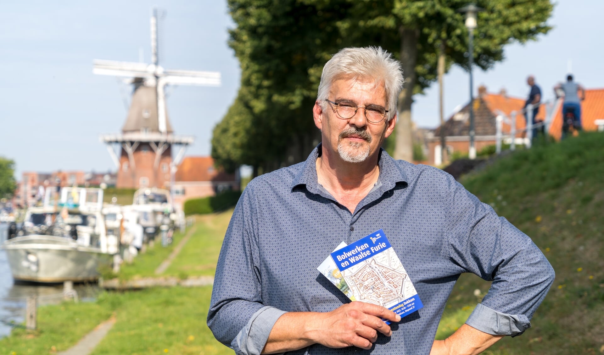 Hans Groeneweg, directeur van Museum Dokkum en tevens voorzitter van het Open Monumentendag-comité Dokkum - Noardeast-Fryslân met op de achtergrond het Baantjebolwerk en molen Zeldenrust.  