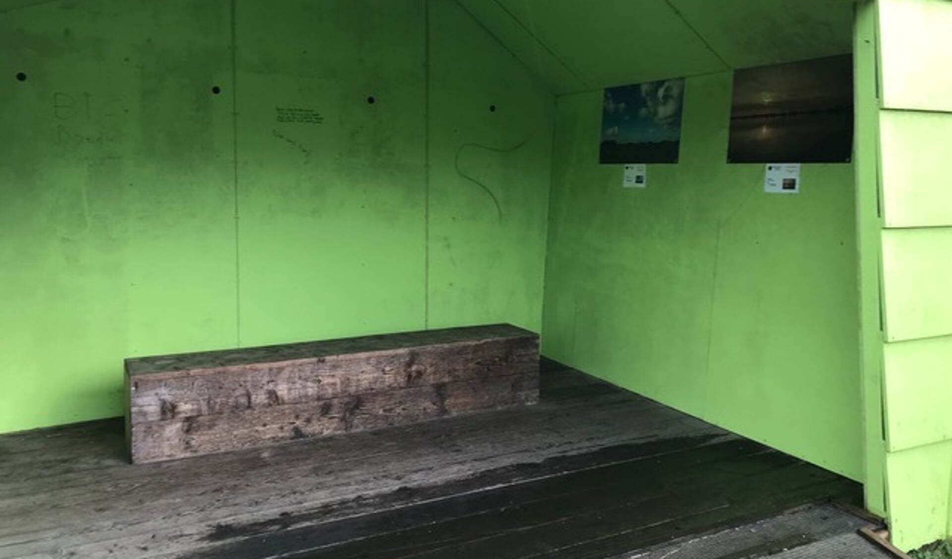 De lege groene muur van het hokje in Park Vijversburg waar de drie gestolen foto's hingen.