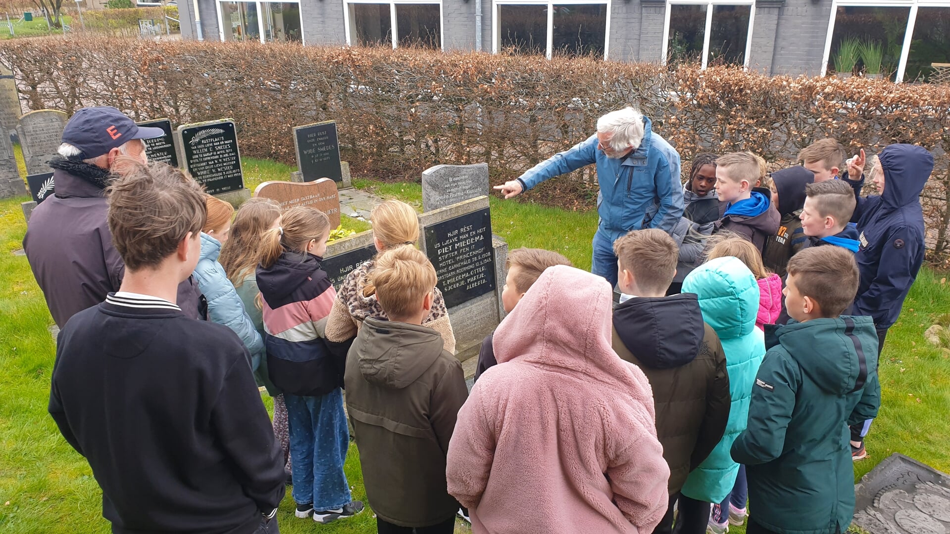 Harm de Vlas geeft uitleg bij het graf van Piet Miedema. Links staat Henk Sijbrandij. 