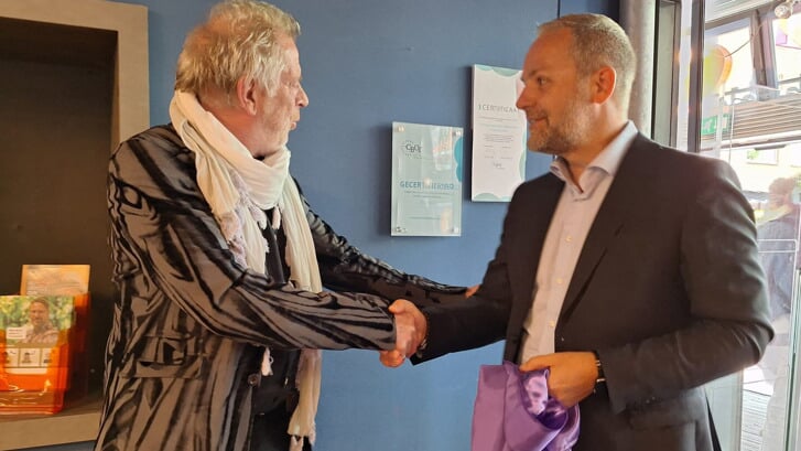 Wethouder Pieter van der Zwan en bibliotheekdirecteur Rien Vrijenhoek te zien bij het onthullen van het certificaatbordje