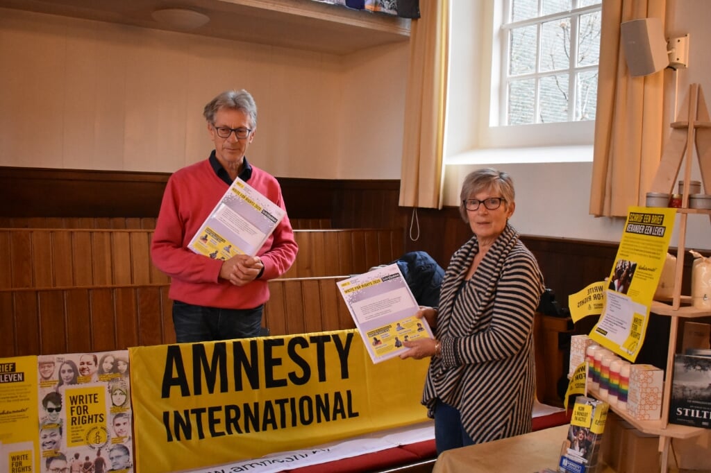 Jehannes en Anna Regnerus bij de kraam van Amnesty International met 'schrijfpakketten' in de Doopsgezinde kerk in Drachten.