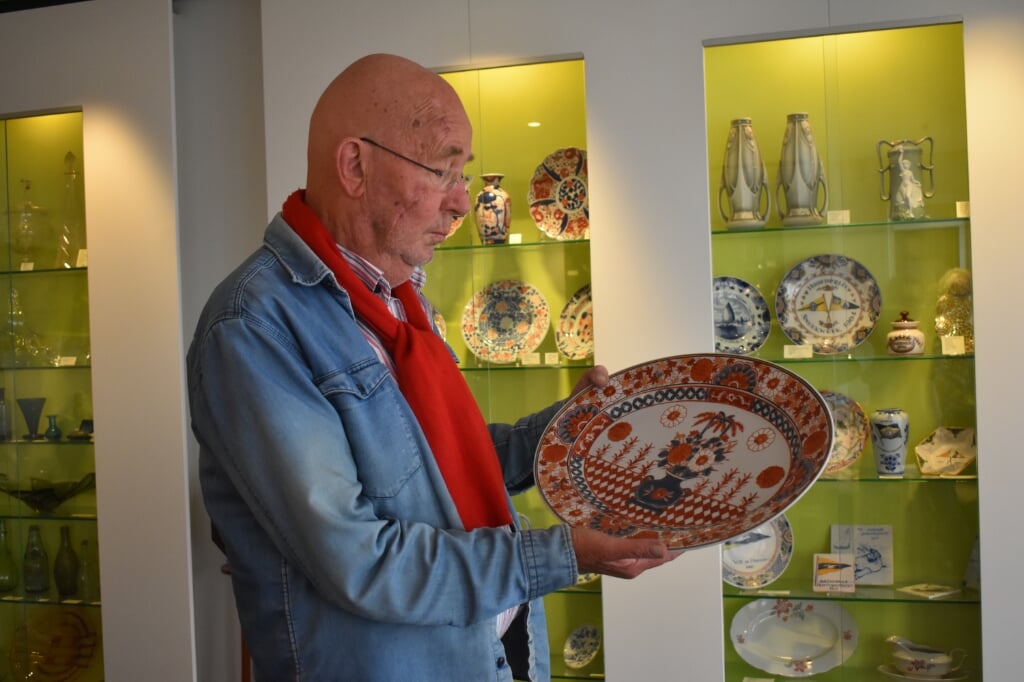 Klaas Henstra toont in zijn antiekwinkel een bord van Japanse makelij.