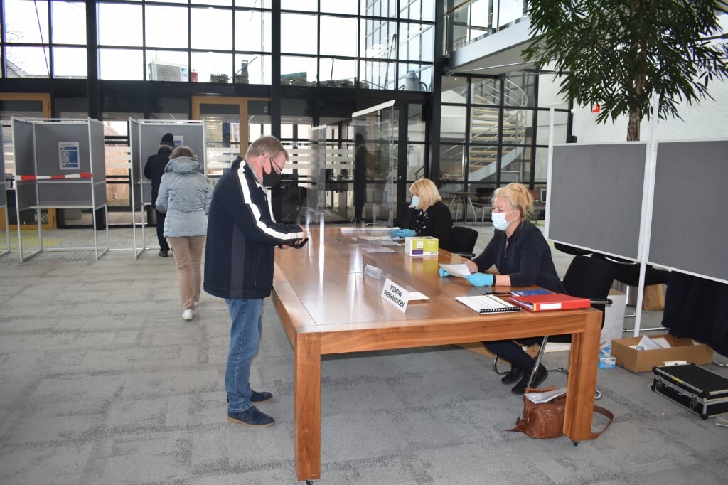 Twee leden van het stembureau in het gemeentehuis in Burgum, achter plexiglas: Ytsje Rosier (rechts) en Dienke Wedman-Posthuma.