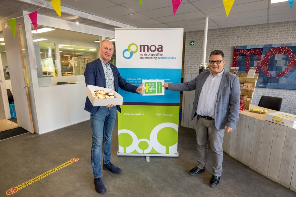 Wethouder Harjan Bruining (links) bezorgt MOA-directeur Sipko Postma een taart.