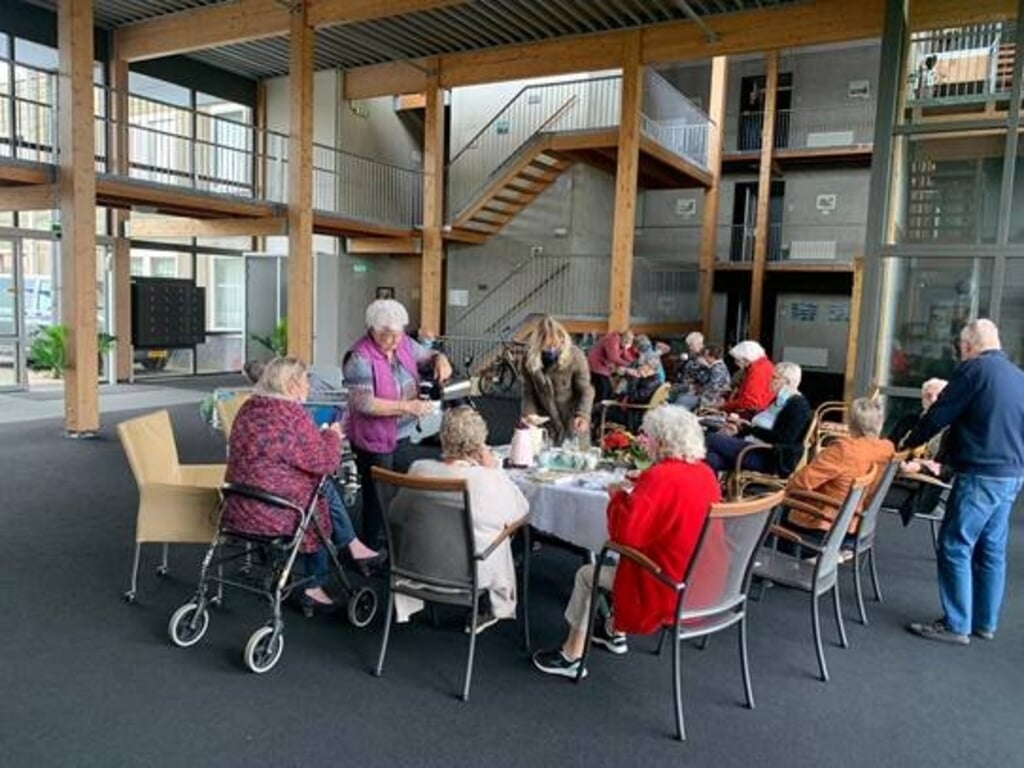 De bewoners van seniorencomplex De Koaster in Kootstertille aan het gebak. 