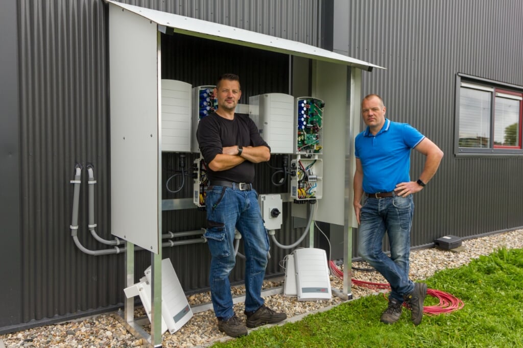 Monteur Peter Martijn Dijkstra en eigenaar Wichard Dijkstra bij een shelter die ze ontwikkelden voor Bakker van den Berg. Onder deze shelter zijn de SolarEdge omvormers geplaatst voor de installatie met 400 zonnepanelen, die eveneens geïnstalleerd zijn door Safe Solar.