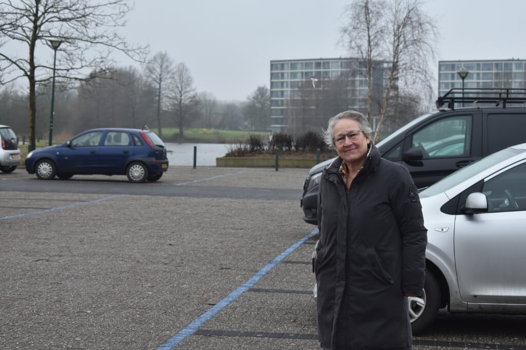Wethouder Maria le Roy van Smallingerland naast een blauwe lijn op het Kyriat Onoplein. Het 'zoneparkeren' wordt hier waarschijnlijk betaald parkeren.