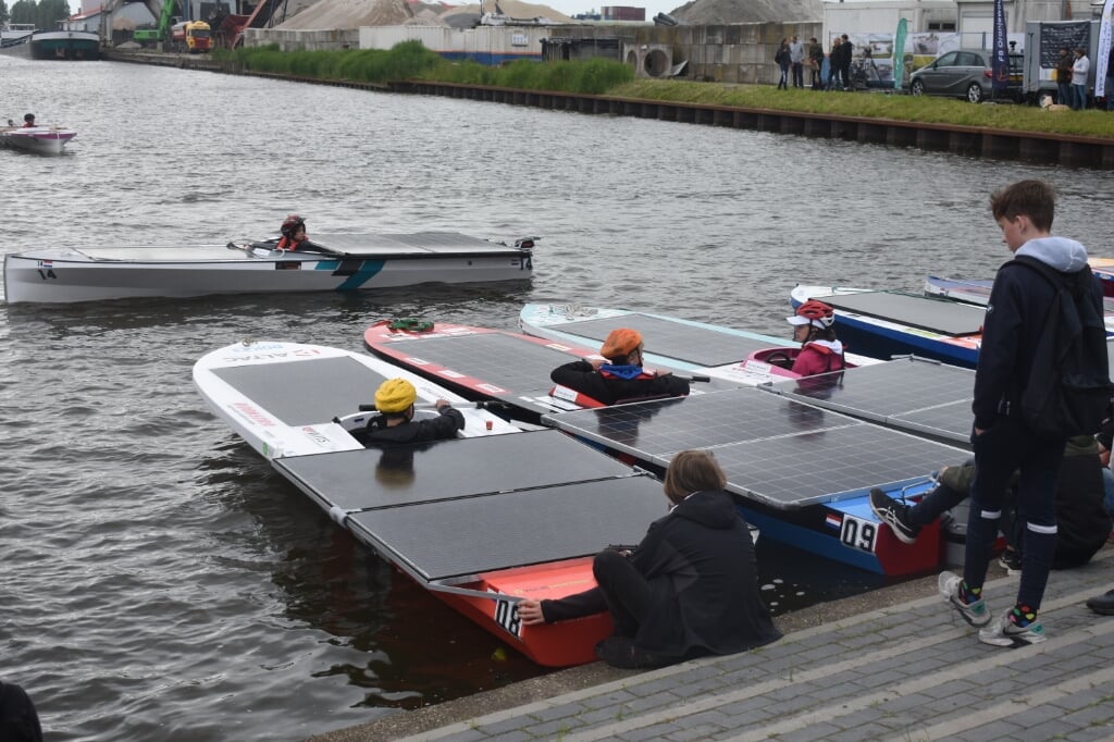 Op de voorgrond boot 08 van het Drachtster Lyceum bij de start in de Zwettehaven in Leeuwarden. In het tussenklassement ligt dit team vierde, 4,5 minuut achter leider Leeuwarder Lyceum (bootnummer 23).