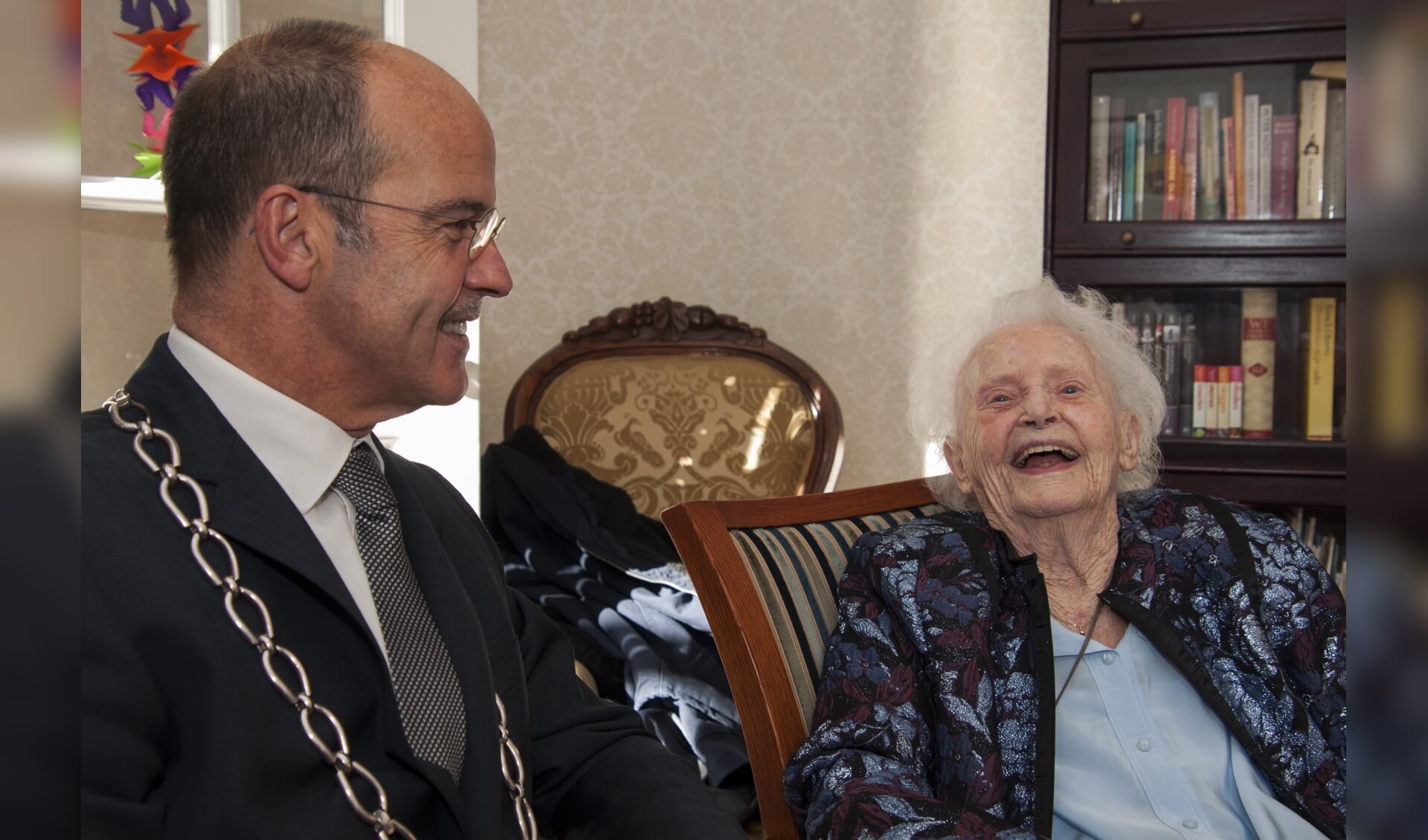 Mevrouw Gijsbers-de Reus schatert om een grapje van burgemeester Alex van Hedel. Foto: Marion Verhaaf