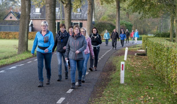 De eerste wandelaars passeren de Vosstraat in Oeken. Foto: Marion Verhaaf