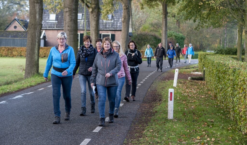 De eerste wandelaars passeren de Vosstraat in Oeken. Foto: Marion Verhaaf