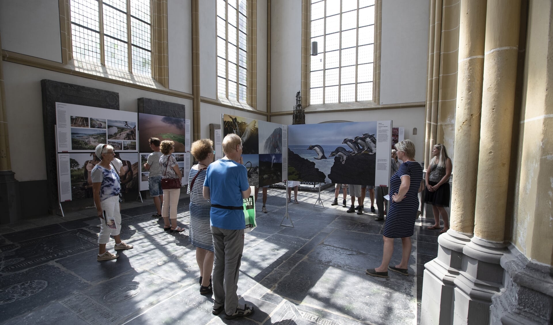 Bezoekers in de World Press Photo tentoonstelling in de Walburgiskerk.