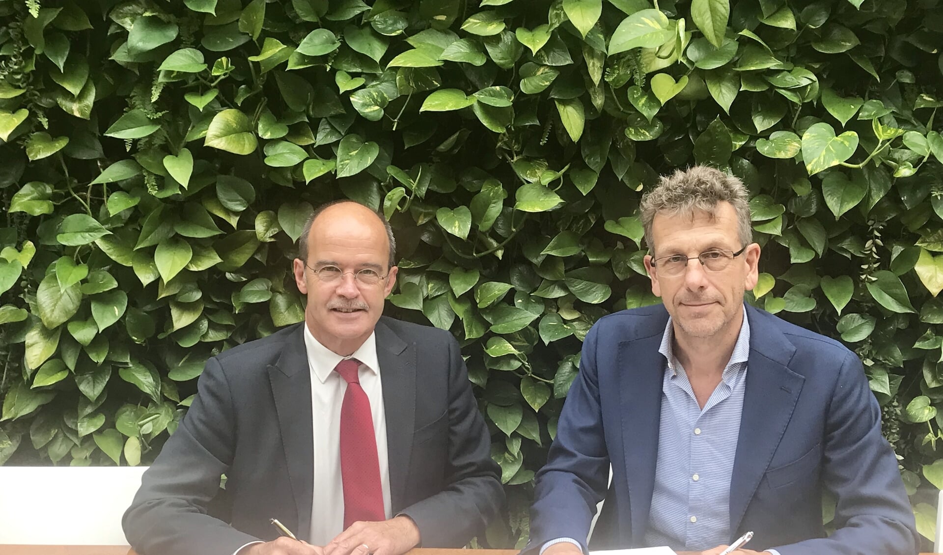 Burgemeester Alex van Hedel en directeur Marco de Wilde ondertekenen de koopovereenkomst.
