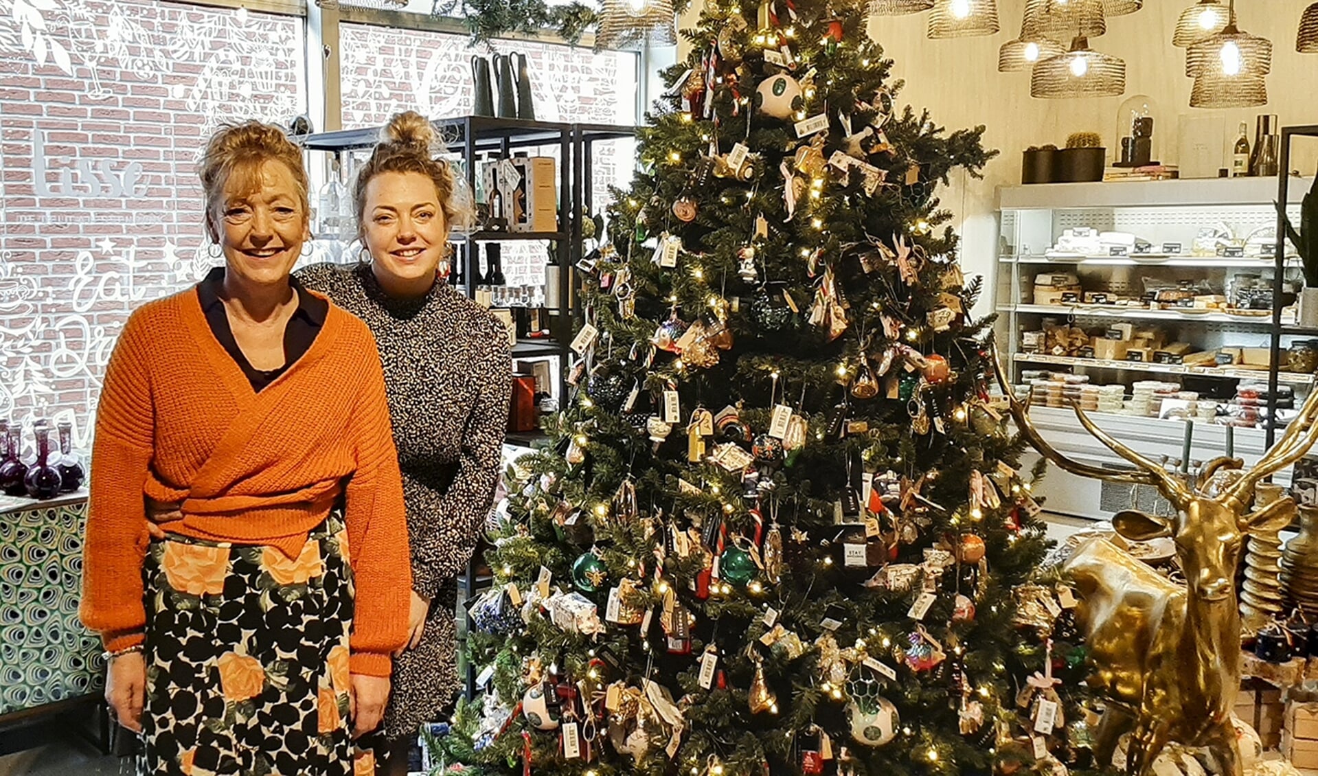 Esmee en Ivonne Beumkes bij een prachtig versierde kerstboom in Lisse, de delicatessenbank. Foto: Marion Verhaaf